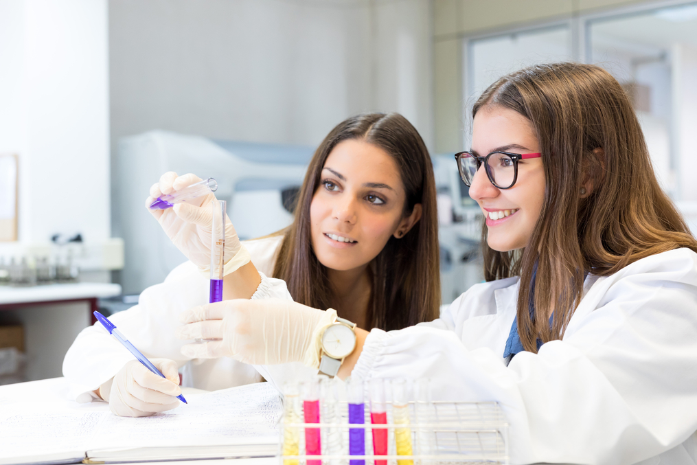 Pharmacy Students pouring chemical into a test tube