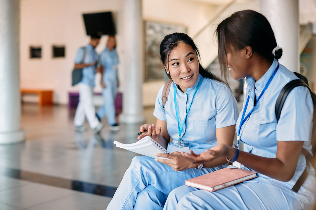 Two medical students sitting together reviewing notes
