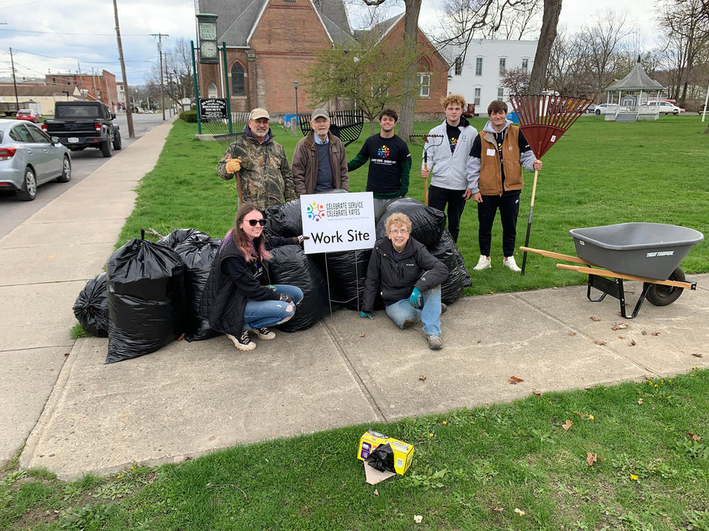 Volunteers posing at work site sign